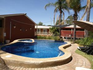伊丘卡伊丘卡老教练汽车旅馆的一座游泳池,位于一座建筑旁的院子内