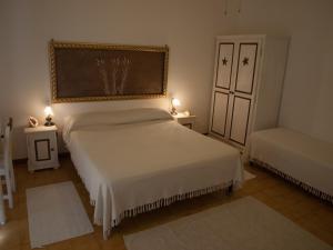 马达莱纳Stella di Mare的一间卧室配有两张床、两张桌子和两盏灯。