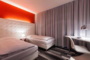 汉堡莫纳帕尔城市酒店的酒店客房配有两张床、一张书桌和一张书桌。