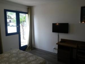 马诺斯克普罗旺斯酒店的酒店客房设有床、电视和窗户。
