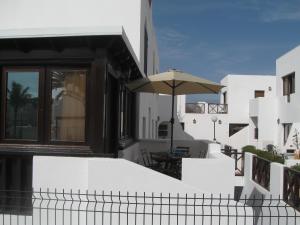 科拉雷侯La Graciosa Apartment的一座白色的建筑,阳台上配有遮阳伞