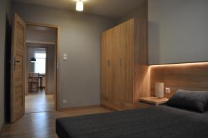什恰夫尼察Apartament Cynamon ,Wanilia i Goździk的一间卧室配有一张床和一个木制床头板