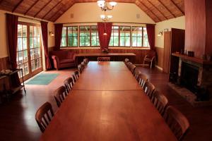 Waimauku库姆葡萄园酒店的大房间设有一张长桌子和椅子
