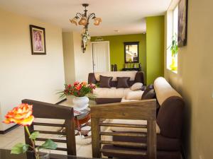昆卡Hotel Las Gardenias的客厅配有沙发和桌子