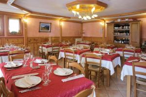 IssimeHotel Posta的餐厅设有红色和白色桌布桌