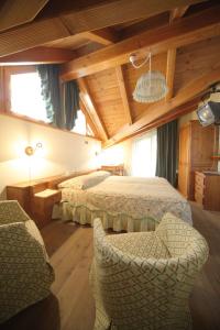 IssimeHotel Posta的一间卧室配有两张床和椅子。