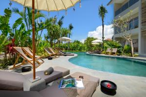 坎古苍谷海滩公寓的一个带躺椅和遮阳伞的度假游泳池