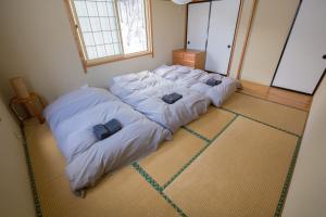 野沢野泽豪斯酒店的一张位于房间的床,上面有两个枕头