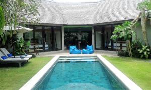 乌鲁瓦图杜克滨金别墅酒店的蓝色枕头房子前面的游泳池