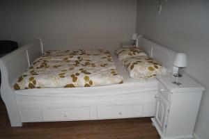 Benk en DonkBed en Breakfast Donkersvoort的卧室配有白色的床和床头柜。