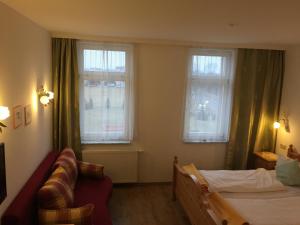 爱尔福特Fürstenhof Landgasthaus & Hotel的一间卧室设有一张床和两个窗户。