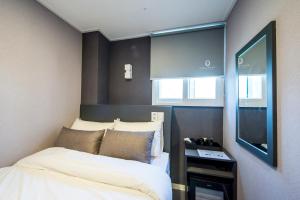 首尔明洞地铁非力斯戴旅馆的小房间设有两张床和电视