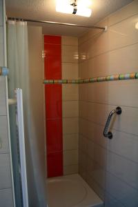 伊尔梅瑙Pavillon an der Ilm的浴室配有浴缸和红色条纹淋浴
