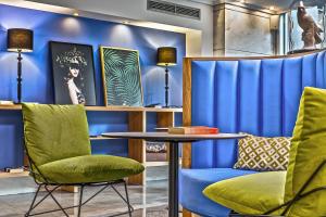 雅典爱若特亚里山德斯酒店的一间拥有蓝色墙壁和桌椅的房间