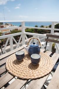 莫罗德哈布雷阿尔贝托SL公寓式酒店的桌子上放着两个杯子,茶壶