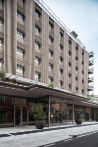 米兰Hotel VIU Milan, a Member of Design Hotels的前面有盆栽植物的大建筑