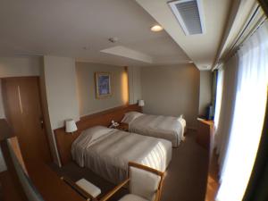 纹别市鄂霍次克宫酒店的酒店客房设有两张床和窗户。