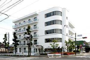 名古屋Guesthouse TOHO的街道拐角处的白色建筑