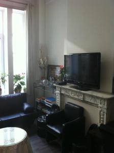 布鲁塞尔18号酒店的客厅设有壁炉,配有平面电视。