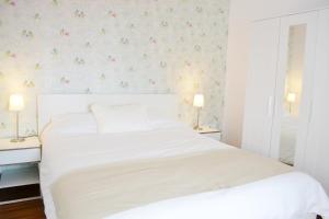 加的斯Ático Compañía的卧室配有白色床和花卉壁纸