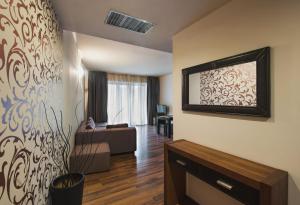 布加勒斯特海明威公寓酒店的客厅配有沙发和墙上的电视