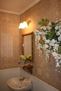 朱利安Julian Gold Rush Hotel的浴室设有水槽、镜子和鲜花