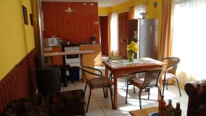 奥索尔诺Cabaña Don Claudio的厨房配有桌椅和冰箱。