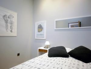 法鲁Casa da Viola - Faro的一间卧室配有一张带黑色枕头的床。