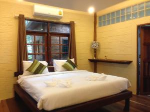 慕斯考艾Treasure Inn Khaoyai的卧室配有一张大白色床和窗户