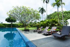 班巴克洛Baan Yamu Private Villa的游泳池旁的一排躺椅