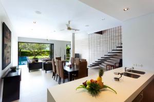 班巴克洛Baan Yamu Private Villa的厨房以及带桌椅的用餐室。