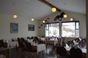 Víðidalstunga丹丽农家乐的一间带桌椅的用餐室和墙上的马