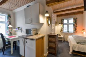 维堡Viborg City Rooms的小房间设有一张床和一间带微波炉的厨房