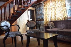 帕雷斯阿吉萨那Gioras Hotel的客厅配有两把椅子、一张沙发和一张桌子