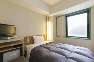横滨新横滨站前R&B酒店的一间卧室配有一张床和一台电视