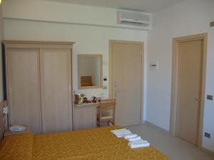 托尔托雷托Hotel Capitano的一间卧室配有一张床、一张桌子和一张书桌