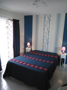 Saint-Mars-la-Jaille阿皮斯特客房旅馆的一间卧室配有两张蓝色和红色的床