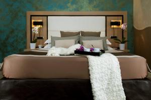 罗马戴美塔酒店的一间卧室配有一张大床和大镜子