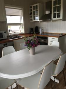 惠拉盖尔济Strýta Guesthouse的厨房里一张白色的桌子,上面有花瓶