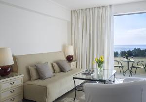 雅典艾默瑞莉雅酒店的带沙发和玻璃桌的客厅