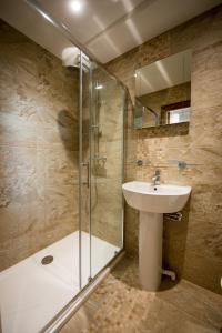 什鲁斯伯里圣尼古拉斯精品酒店 的一间带水槽和玻璃淋浴的浴室