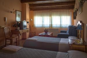 塞利亚La Posada de Clotilde的一间卧室配有一张床、一张沙发和一台电视。