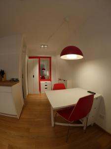 班贝格Haus "Zum Schwarzen Stiefel"的一间设有白色桌子和两张红色椅子的房间