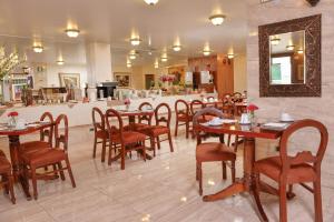库斯科茹尼斯酒店的餐厅设有木桌、椅子和柜台
