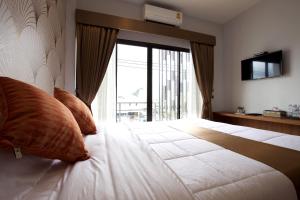 清莱777食宿酒店的一间卧室设有一张大床和大窗户