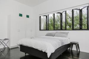 拉罗汤加Mata Manea的白色客房的一张床位,设有窗户