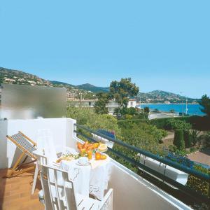 阿盖艾丝特雷拉罗吉斯酒店的阳台配有桌椅,享有海景。