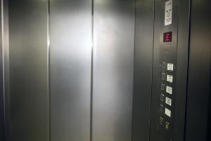 汉堡拉法耶特酒店的带有金属门的电梯,上面有标志