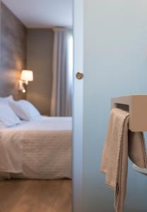 厄尔·波普瑙·德尔·戴尔三角洲拉尔加迪尔酒店的一间酒店客房,门上有一床和一条毛巾