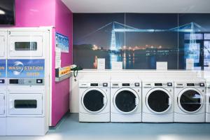 纽波特新港大学村公寓（校园住宿）的洗衣房设有3台洗衣机和大窗户